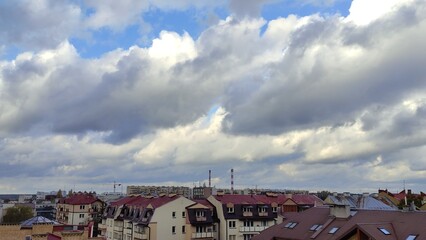 Low large clouds float over the city. Late autumn