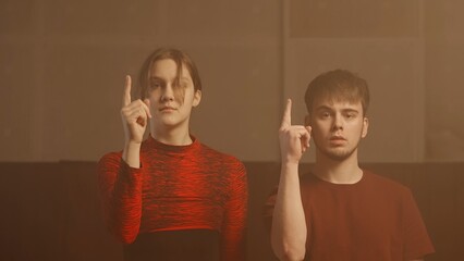 Professional dancers performing dance show. Young man and woman contemporary dancers perform modern choreography elements in smoke, middle shot.