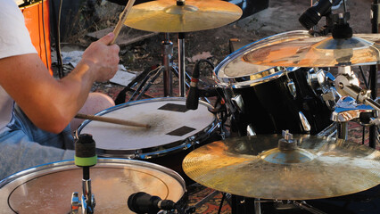 A passionate drummer immersed in the rhythm, skillfully playing the drum set. The image captures...