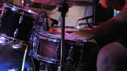 Professional drum kit illuminated with spectacular lights, ready to perform. Drum kit in the spotlight on stage.