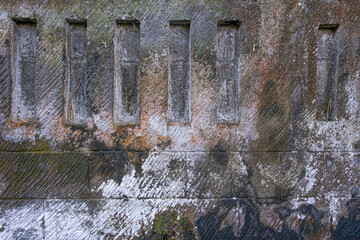 Gray and slate colored concrete wall with imperfections. Background and wallpaper texture.