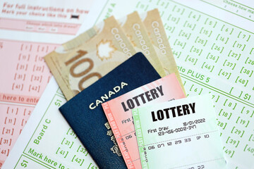Lottery tickets lies with canadian dollars on gambling sheets with numbers for marking to play lottery. Lottery playing concept or gambling addiction