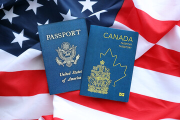 Fototapeta premium Passport of Canada with US Passport on United States of America folded flag close up