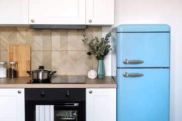 Front view of stylish nordic interior design in kitchen with blue refrigerator
