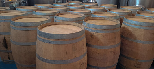 Wooden barrels with stacked wine stored in cellar with oak color