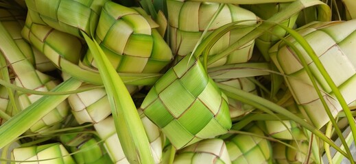 Ketupat or rice dumpling. A traditional rice casing made from young coconut leaves for cooking rice sold in traditional market preparation for the Eid al-Fitr holiday for Muslim - obrazy, fototapety, plakaty