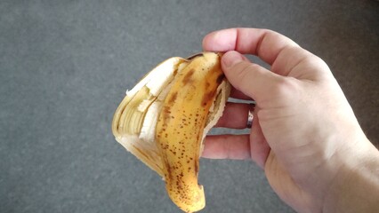 Man holds a banana skin in his hand