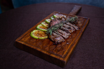 Beef steak with grilled zucchini on a wooden board