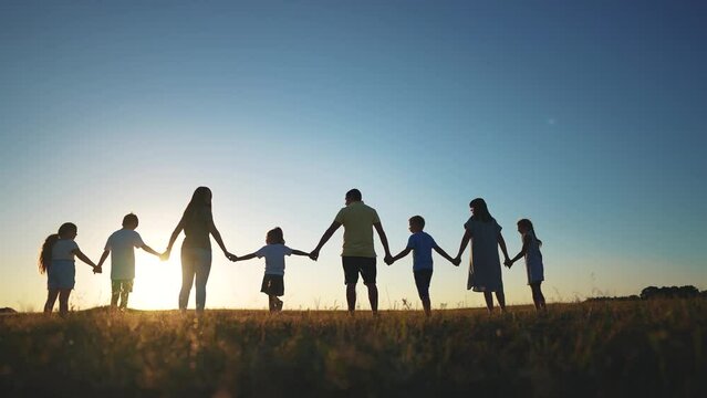 big family. huge community family holding hands walking in the park at sunset. happy family kid dream concept. big family community walking with children in the park. friendly people walking sunlight