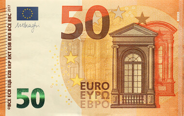 Fragment of one fifty euro money bill. Details of European union currency banknote of 50 euro close...