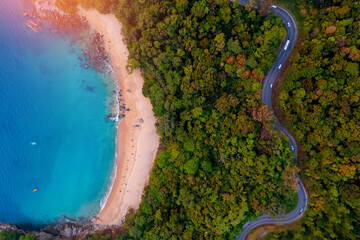 Aerial top view Phuket, sand beach of paradise sea and winding road, sunset time. Tropical travel photo of Thailand