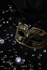 Masquerade gold mask with gemstones on black background.