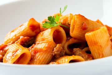 Primo piano di deliziosi rigatoni con sugo di salsiccia, pasta italiana, cibo europeo  - 779883203