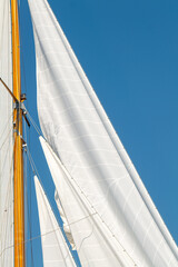 White Dacron sails on a classic wooden sail boat with wooden masts.