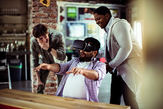 Young men using a vr headset while working in a startup company office