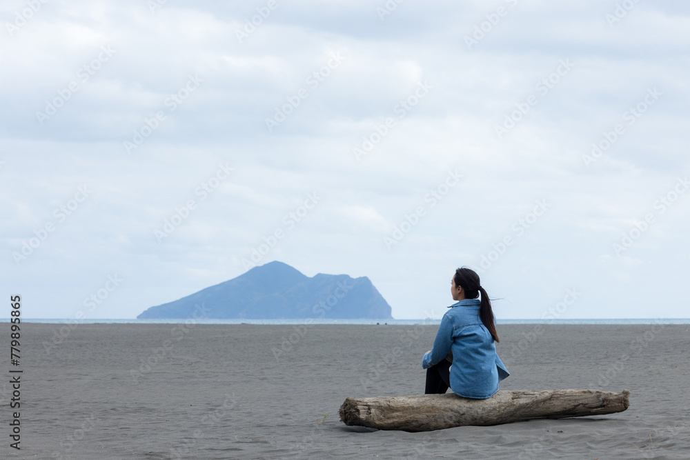 Sticker woman sit on the beach and look at the guishan at yilan