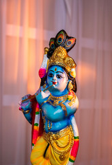 Hindu God Krishna sculpture isolated on white curtain