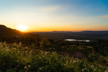 Picture of Khao Kho viewpoint with mountains and grassland during the time the sun is setting.