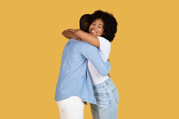 Couple hugging each other gently on yellow