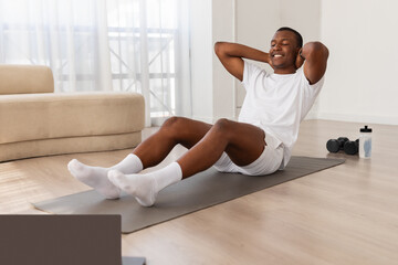 Man doing sit-ups at home on yoga mat