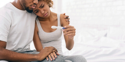 Black couple with a negative pregnancy test result - obrazy, fototapety, plakaty