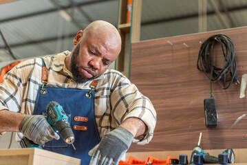 Carpenter man Portrait of Young black skin working in workshop. Happy professional Carpenter holds...