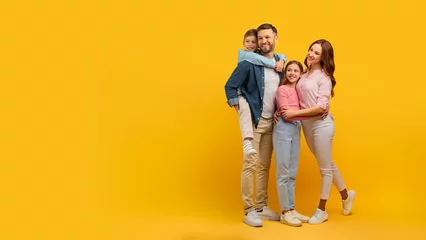 Poster Family embraced and smiling on yellow background © Prostock-studio