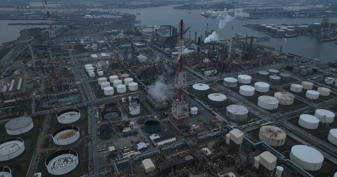 Refineries and the three steam crackers in the port of Antwerp, Belgium at dusk. Petrochemical silos and storage containers. Chemical production, oil and chemical production. Aerial drone view.