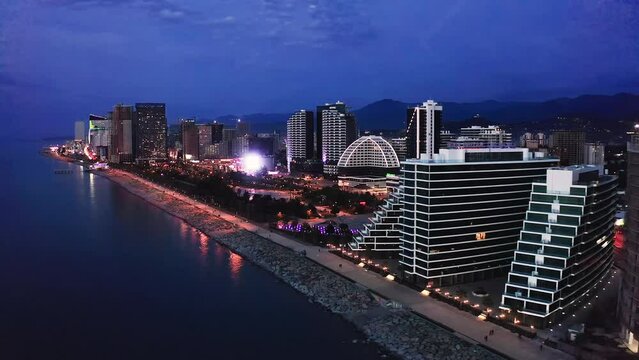 Aerial view of Batumi city in Georgia. Famous touristic coast with ferris wheel and high buildings with cityscape at background
