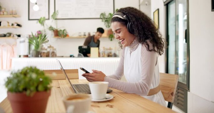 Headphones, laptop and woman with phone in coffee shop networking on social media or internet. Technology, smile and female creative freelancer type email on cellphone and working on computer in cafe