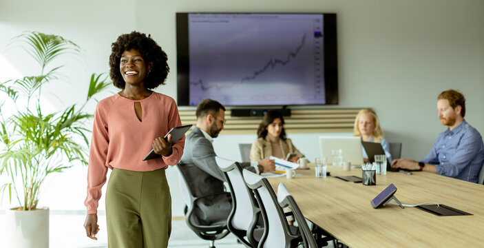 Radiant African American businesswoman with tablet ready to present in modern conference room