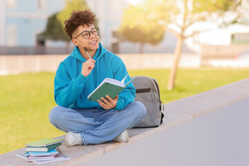 Student studying outside with books, copy space
