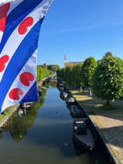Frisian flag at the canal in Sloten - obrazy, fototapety, plakaty