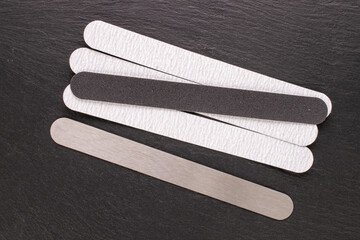 Manicure files with interchangeable files on slate stone, top view.