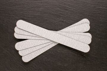 Manicure files with interchangeable files on slate stone, top view.