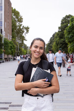 Happy aboriginal female university student holding textbooks