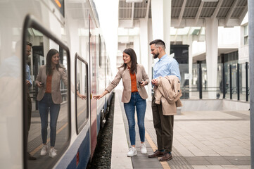 Business couple on train station entering on train