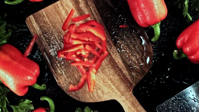 Super slow motion chopped sweet peppers fall on a cutting board. High quality FullHD footage