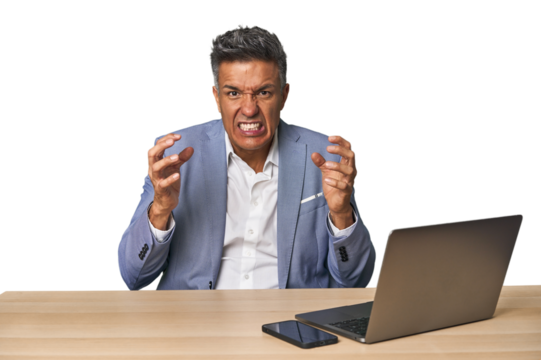 Elegant businessman at desk with laptop screaming with rage.