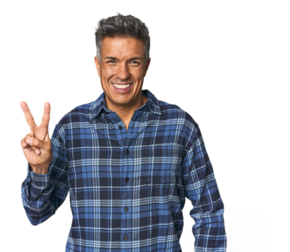 Middle-aged Latino man showing victory sign and smiling broadly.