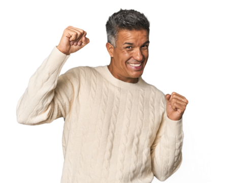 Middle-aged Latino man celebrating a special day, jumps and raise arms with energy.