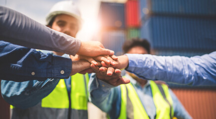 Close-up of Engineering team making pile of hands with cargo container background at sunset. Logistics global import or export shipping industrial concept.