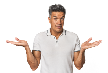 Middle-aged Latino man confused and doubtful shrugging shoulders to hold a copy space.