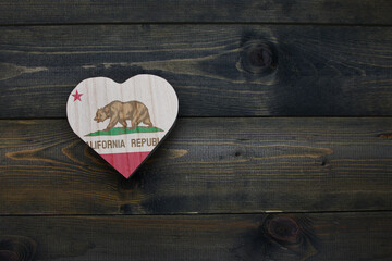 wooden heart with national flag of california state on the wooden background.
