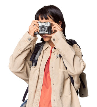 Young Hispanic traveler with vintage camera in studio setting