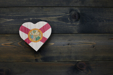 wooden heart with national flag of florida state on the wooden background.