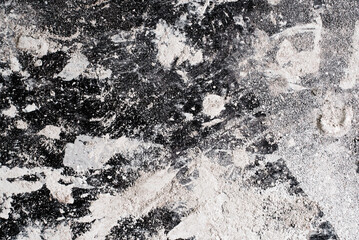 White powder, chalk, plaster, plaster are scattered on a black surface. Texture grunge background