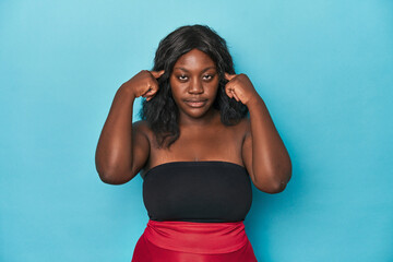 Young african american curvy woman focused on a task, keeping forefingers pointing head.