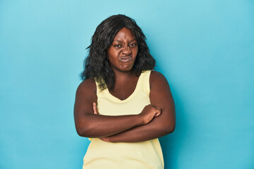 Young african american curvy woman frowning face in displeasure, keeps arms folded.