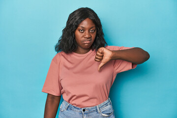 Young african american curvy woman showing thumb down, disappointment concept.